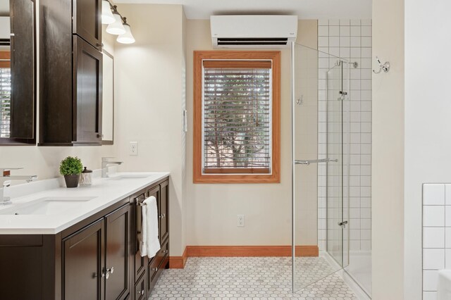 full bathroom featuring a sink, tiled shower, and a wall unit AC