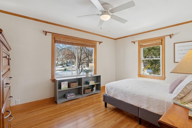 bedroom featuring light wood-type flooring, baseboards, ornamental molding, and a ceiling fan