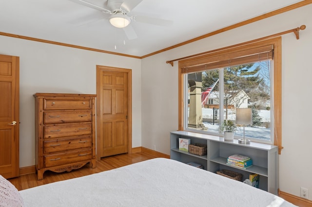 bedroom with ornamental molding, ceiling fan, baseboards, and wood finished floors