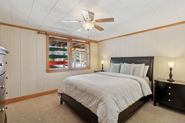 bedroom with carpet flooring, baseboards, crown molding, and ceiling fan