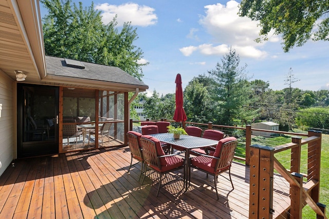 wooden terrace with outdoor dining space and a sunroom