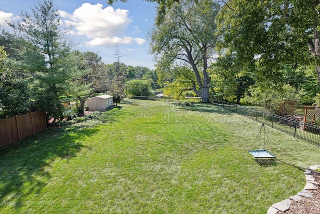 view of yard with a fenced backyard, a storage shed, and an outdoor structure