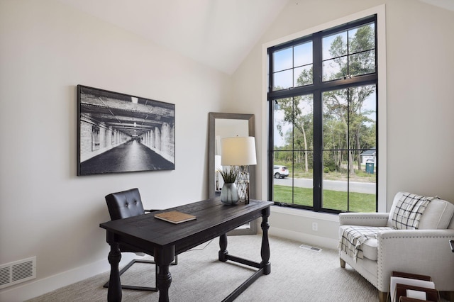 carpeted home office with vaulted ceiling