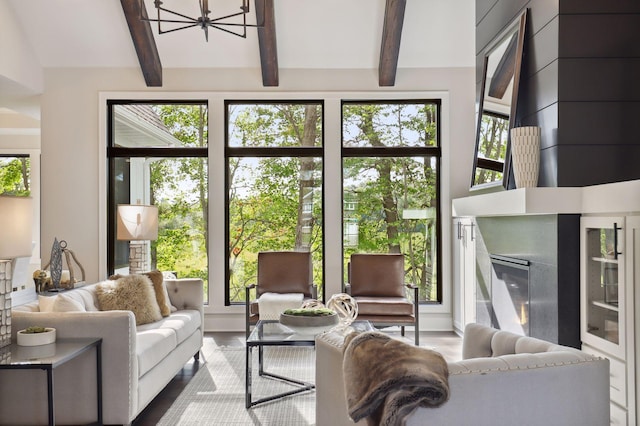 living room with beamed ceiling, a chandelier, and a healthy amount of sunlight