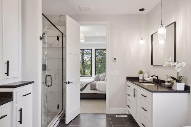 bathroom featuring tile patterned flooring, vanity, and walk in shower