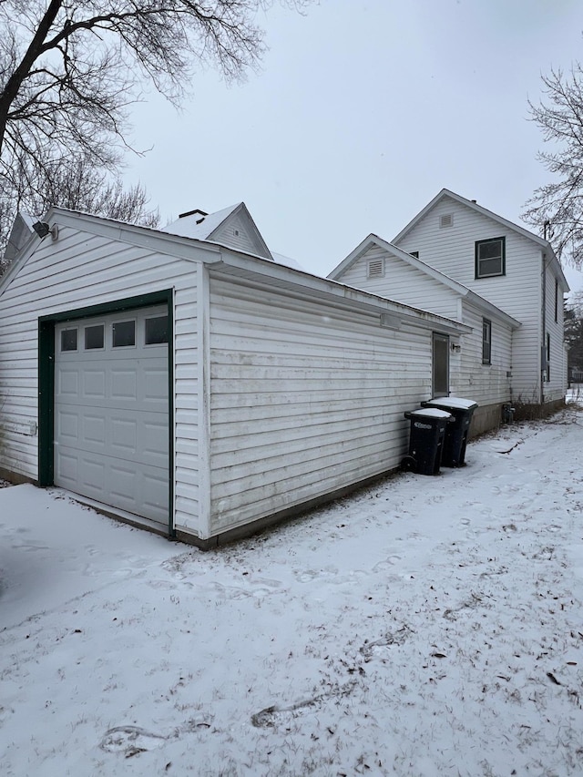 view of snowy exterior featuring a garage