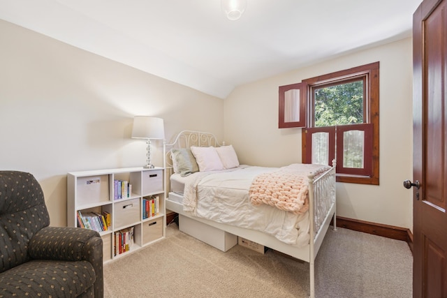 bedroom with light colored carpet and vaulted ceiling