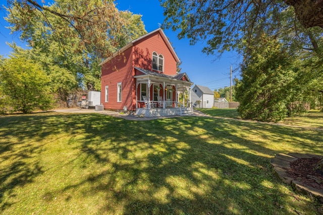 back of house featuring a yard, central AC unit, and a porch