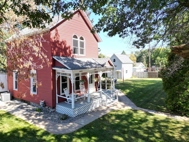 back of property featuring a lawn, covered porch, and central AC unit