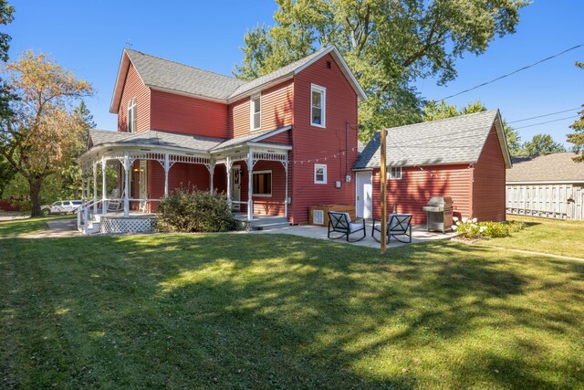 back of house with covered porch, a yard, and a patio