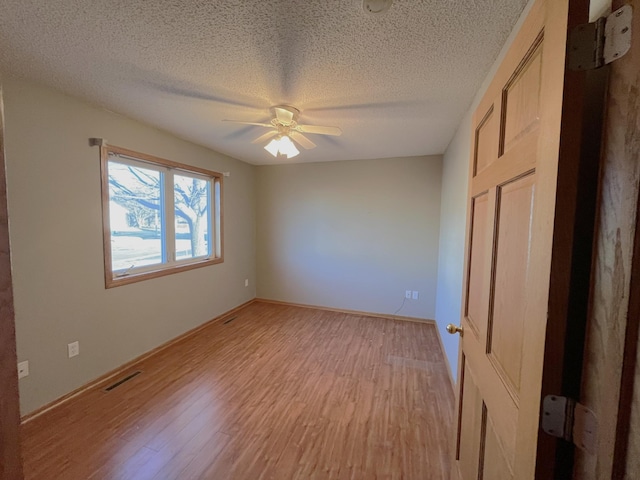 unfurnished bedroom with a textured ceiling, light hardwood / wood-style flooring, and ceiling fan