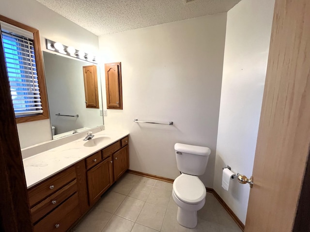 bathroom featuring tile patterned floors, vanity, a textured ceiling, and toilet