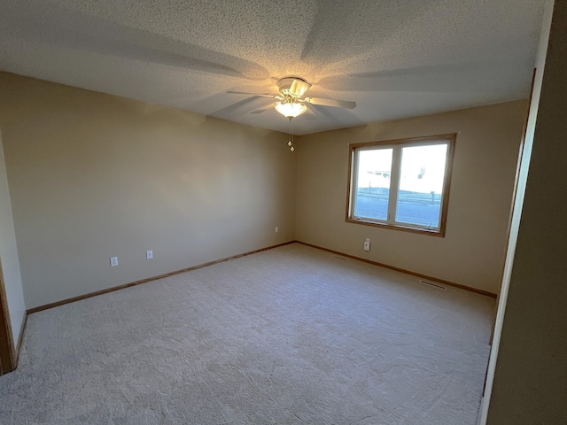 carpeted empty room featuring ceiling fan and a textured ceiling