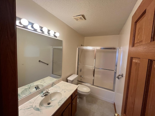 full bathroom featuring toilet, combined bath / shower with glass door, a textured ceiling, and vanity