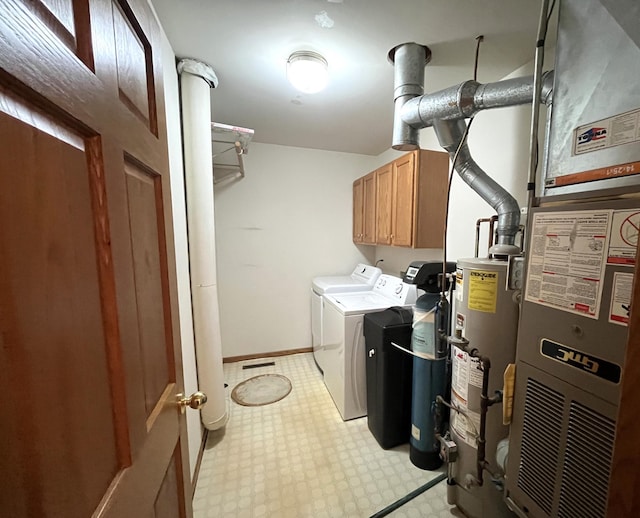 laundry room with separate washer and dryer, water heater, and cabinets