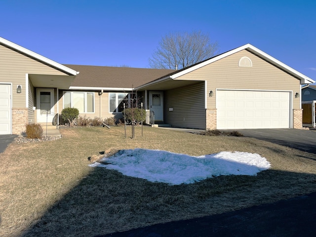 ranch-style house featuring a garage and a front lawn