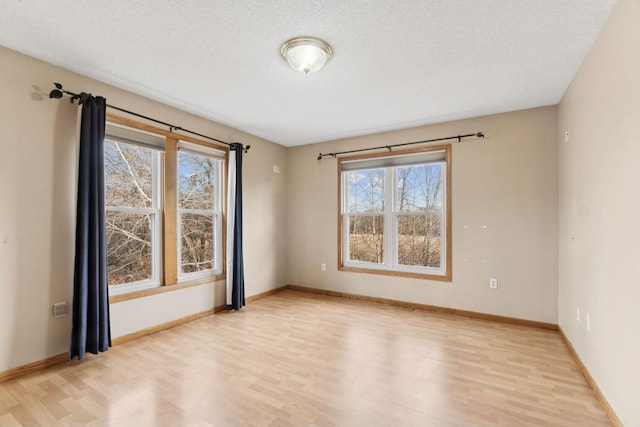 spare room with light hardwood / wood-style flooring and a textured ceiling