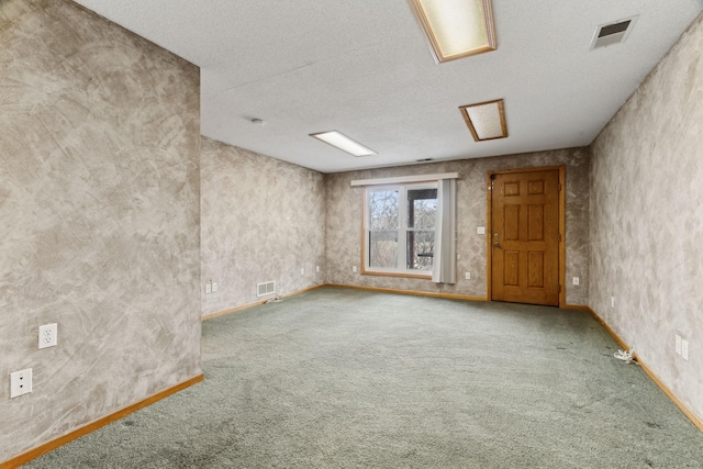 carpeted spare room with a textured ceiling