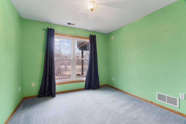 carpeted empty room with a textured ceiling