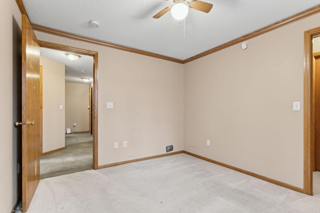 carpeted empty room with ceiling fan, a textured ceiling, and ornamental molding