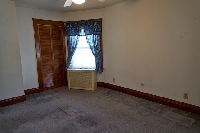 unfurnished bedroom featuring carpet floors, radiator heating unit, a closet, and baseboards