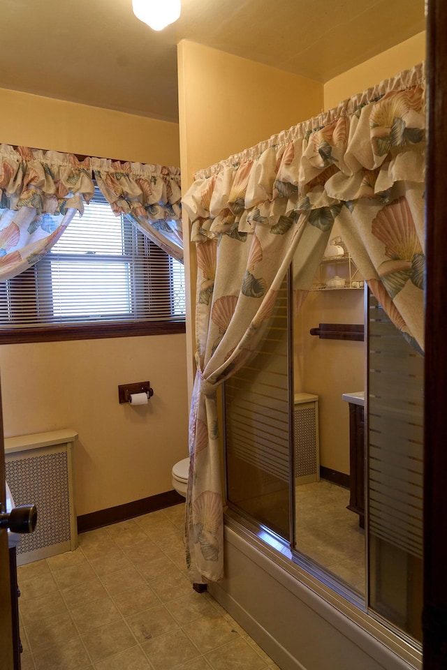 bathroom with toilet, shower / bath combination with glass door, baseboards, tile patterned floors, and radiator