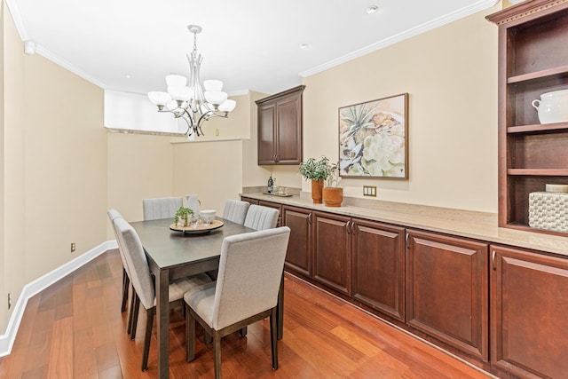 dining area featuring hardwood / wood-style flooring, a notable chandelier, and ornamental molding