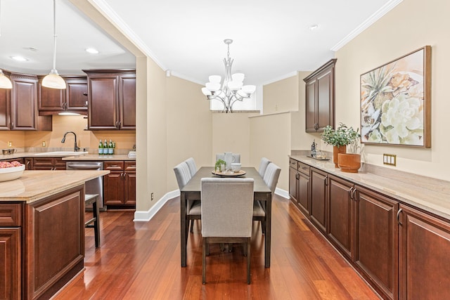 dining area with crown molding, dark hardwood / wood-style flooring, a chandelier, and sink