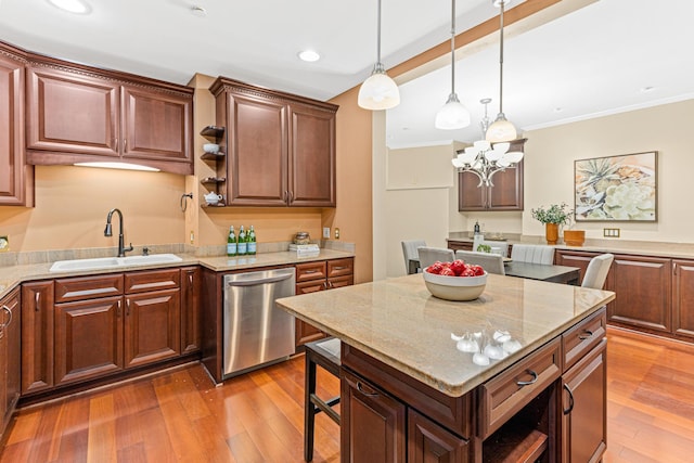 kitchen with sink, stainless steel dishwasher, a notable chandelier, hardwood / wood-style floors, and a kitchen island