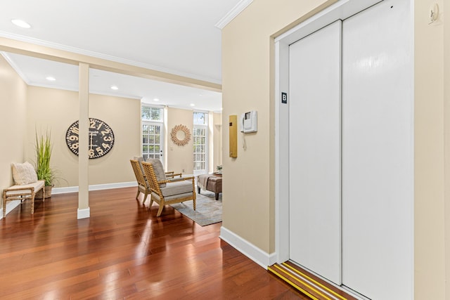 entrance foyer featuring elevator, wood-type flooring, and ornamental molding