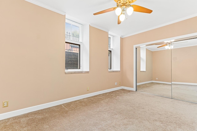 unfurnished bedroom with carpet, a closet, ceiling fan, and ornamental molding