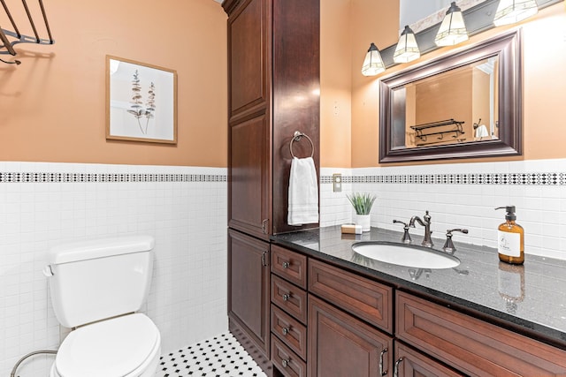 bathroom with tile patterned floors, vanity, tile walls, and toilet