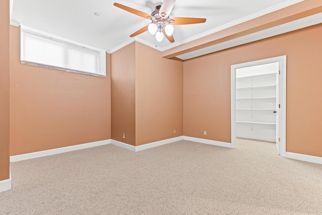 carpeted empty room with ceiling fan and crown molding