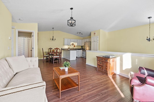 living room with dark wood-type flooring, vaulted ceiling, and a chandelier