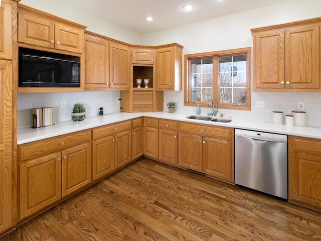 kitchen with sink, black microwave, dark hardwood / wood-style flooring, decorative backsplash, and stainless steel dishwasher