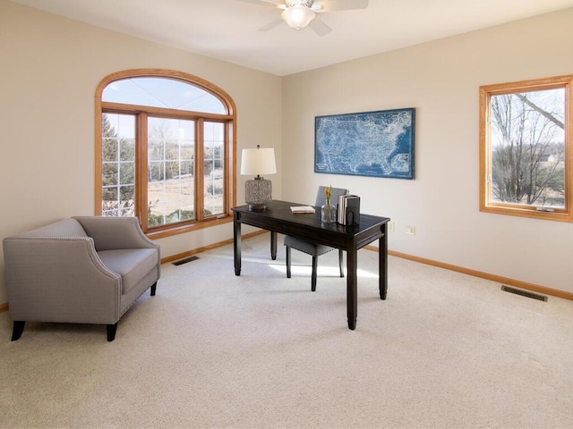 home office featuring light carpet and ceiling fan