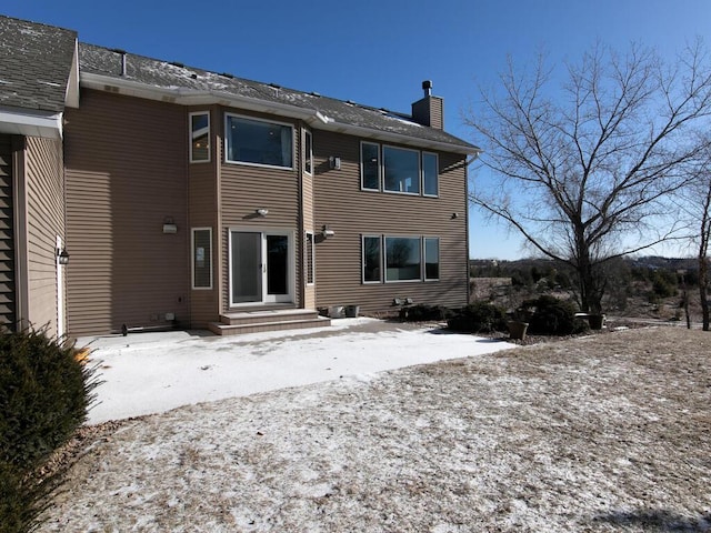 view of snow covered rear of property