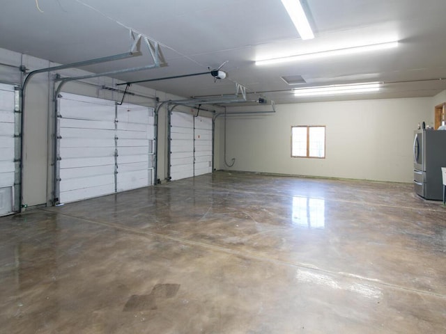 garage featuring a garage door opener and stainless steel refrigerator