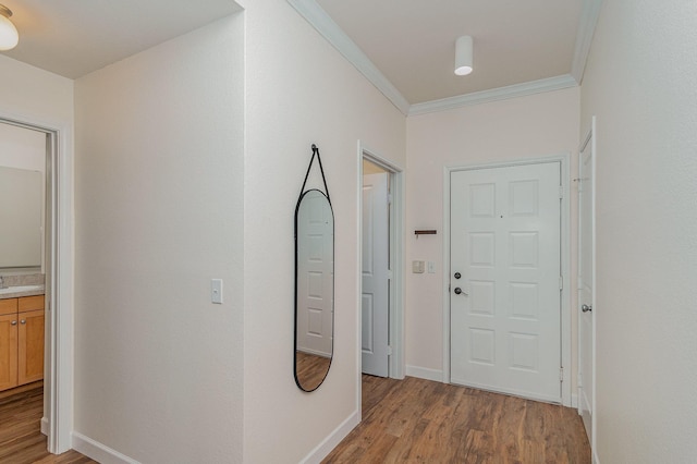 hall with light wood-type flooring and ornamental molding