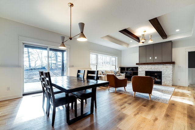 dining space with ceiling fan, light wood-type flooring, and a tray ceiling