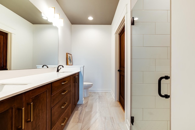 bathroom featuring toilet, vanity, and walk in shower