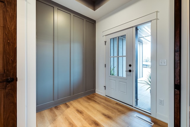 foyer with light wood-style floors and baseboards