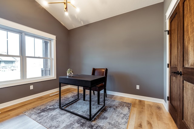 office area featuring vaulted ceiling, light wood finished floors, and baseboards