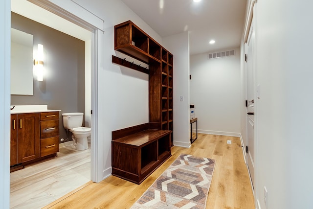 mudroom with light wood finished floors, recessed lighting, and baseboards