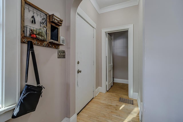 hall featuring crown molding and light hardwood / wood-style floors