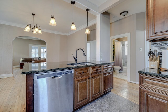 kitchen with dishwasher, sink, hanging light fixtures, a notable chandelier, and a center island with sink