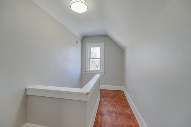 hallway featuring dark wood-type flooring and lofted ceiling