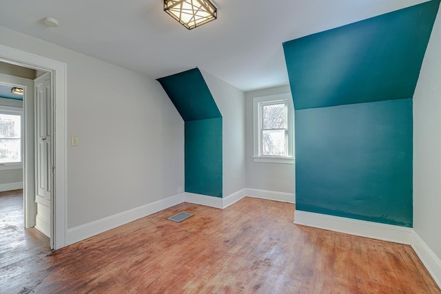 bonus room with lofted ceiling and light hardwood / wood-style flooring