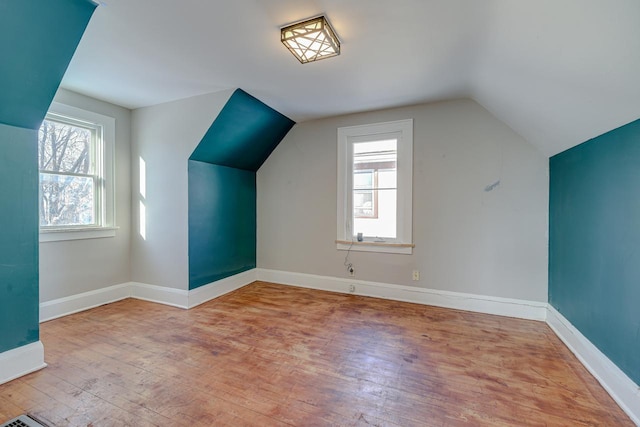 additional living space with a wealth of natural light, light wood-type flooring, and vaulted ceiling