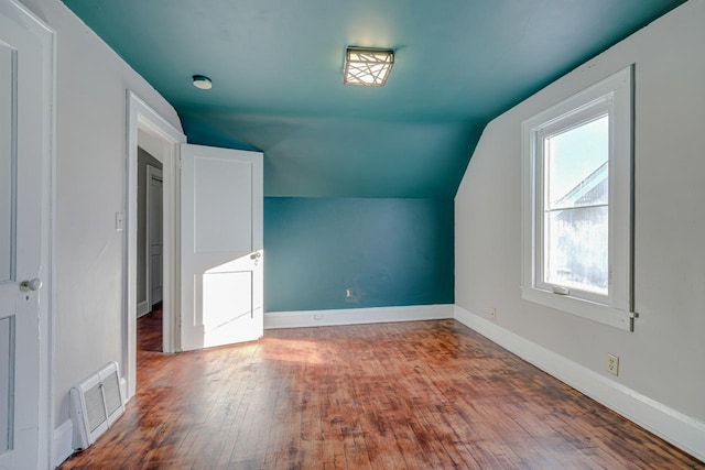 additional living space featuring vaulted ceiling, plenty of natural light, and wood-type flooring